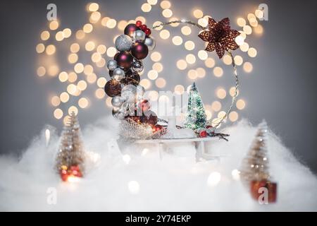 Concept de déoration de Noël sur les vacances avec un derr porcelaine, fausse neige blanche pour un décembre festif. En arrière-plan sont des boules de bokeh faites de lumière Banque D'Images