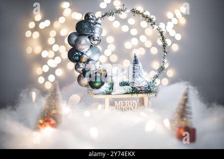 Concept de déoration de Noël sur les vacances avec un derr argenté, fausse neige blanche pour un décembre festif. En arrière-plan sont des boules de bokeh faites de lumières Banque D'Images