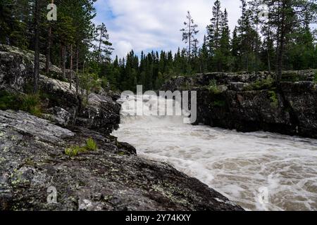 Cascade cascades dramatiques sur un terrain rocheux, la puissance brute de la nature et la beauté le long de la rivière dans la forêt sauvage d'Idre Dalarna Suède. Banque D'Images