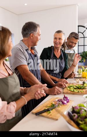 Préparer des légumes, des amis âgés divers cuisiner ensemble et profiter de la conversation dans la cuisine, Banque D'Images