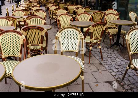 Des chaises et des tables en osier vides au café européen en plein air par une journée nuageuse Banque D'Images