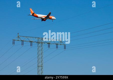 Airbus A320 EasyJet Landing approche Flying Jetliner vol commercial approche avion survolant une ligne électrique dans un ciel bleu, Berlin Banque D'Images