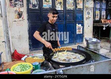 Naplouse, Palestine. 27 septembre 2024. Un palestinien cuisine des falafels dans le camp de réfugiés de Balata, à l'est de Naplouse, dans le nord de la Cisjordanie occupée. (Photo de Nasser Ishtayeh/SOPA images/Sipa USA) crédit : Sipa USA/Alamy Live News Banque D'Images