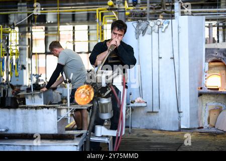 Karlovy Vary, République tchèque - 12 août 2024 : souffleur de verre ou Gaffer soufflant un verre dans l'usine Moser. Banque D'Images