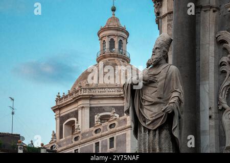 Vue sur la cathédrale de Catane, Sicile, présentant son architecture baroque avec le dôme emblématique et une statue d'un saint. L'image capture l'int Banque D'Images