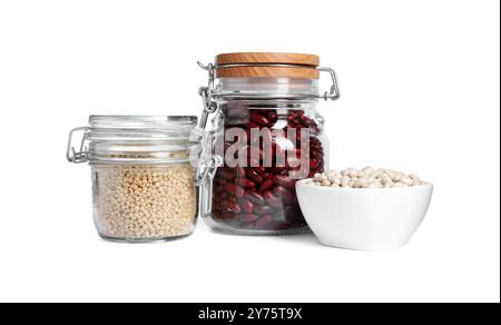 Différents types de légumineuses et couscous crus dans la vaisselle isolés sur blanc Banque D'Images