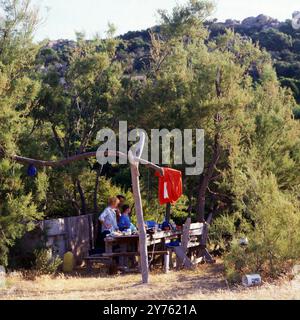 Touristen auf einer Schlauchboottour schagen ihr Lager an der Küste der Insel Korsika auf, um 1985. Banque D'Images