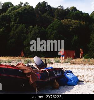 Touristen auf einer Schlauchboottour schagen ihr Lager an der Küste der Insel Korsika auf, um 1985. Banque D'Images