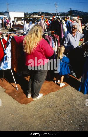 Verkäufer und Kunden an einem Bekleidungsstand auf einem Straßenmarkt am Tag vor dem Loma Prieta Erdbeben in San Francisco, USA 1989. Banque D'Images