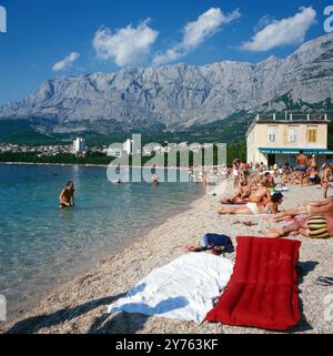 Hinter dem Tucepi Strand von Makarska erhebt sich das Biokovo Bergmassiv in der Region Kroatien, Jugoslawien um 1981. Banque D'Images