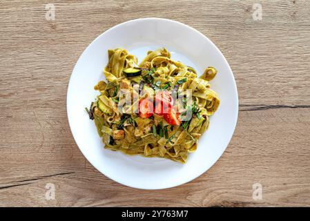Pesto avec tagliatelles avec poulet et tomates cerises couchées sur une assiette. Banque D'Images