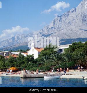 Hinter dem Strand von Baska Voda an der Makarska Riviera direkt die Stadt und die Kirche des Orts in der Region Kroatien, Jugoslawien um 1981. Banque D'Images