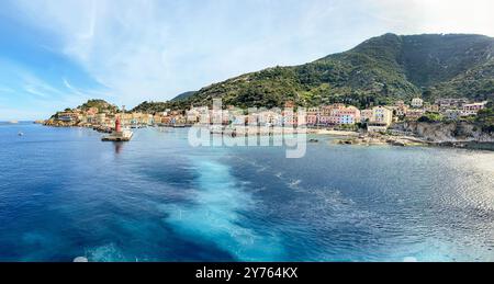 Vue sur le port et la vieille ville de Giglio Porto à Isola del Giglio, île de l'archipel toscan, beaux bâtiments rustiques anciens et terme de ferry Banque D'Images