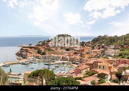 Vue sur le port et la vieille ville de Giglio Porto à Isola del Giglio, île de l'archipel toscan, beaux bâtiments rustiques anciens et terme de ferry Banque D'Images