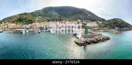 Vue sur le port et la vieille ville de Giglio Porto à Isola del Giglio, île de l'archipel toscan, beaux bâtiments rustiques anciens et terme de ferry Banque D'Images