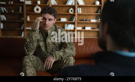 Triste client caucasien réfléchi homme déprimé militaire soldat homme officier en uniforme de combat Guy défenseur tenant la tête souffrant de dépression TSPT Banque D'Images