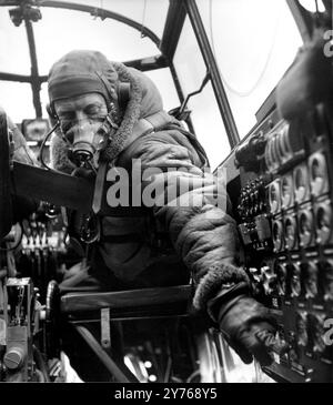 Un ingénieur de vol de Lancaster dans le cockpit d'un bombardier Avro Lancaster, alias Lancs était un bombardier lourd britannique de la seconde Guerre mondiale adopté par la Royal Air Force (RAF). Développé à l'origine comme une évolution du Manchester (qui s'était avéré gênant en service et a été retiré en 1942), le Lancaster a été conçu par Roy Chadwick et propulsé par quatre Rolls-Royce Merlin. Il a été mis en service pour la première fois avec la RAF Bomber Command en 1942 et comme l'offensive de bombardement stratégique au-dessus de l'Europe a pris de l'ampleur, il a été le principal avion pour les campagnes de bombardement nocturnes qui ont suivi. Banque D'Images