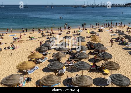 Baigneurs allongés sur des parasols en bois et des chaises longues à Praia da Duquesa dans la ville portugaise de Cascais, Cascais, Lisbonne District, Portugal, Europe. Banque D'Images