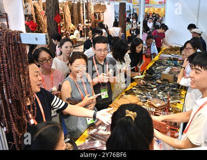 Nanning, région autonome chinoise du Guangxi Zhuang. 28 septembre 2024. Les visiteurs achètent des produits au Pavillon du Vietnam lors de la 21e exposition Chine-ASEAN à Nanning, dans la région autonome du Guangxi Zhuang, au sud de la Chine, le 28 septembre 2024. Les produits des pays de l'Association des Nations de l'Asie du Sud-est (ASEAN), tels que les durians, les biscuits et le bois de rose, ainsi que ceux d'autres pays, y compris les saucisses russes et les peluches d'alpaga péruvien, ont connu une grande popularité lors de la 21e exposition Chine-ASEAN à Nanning. Crédit : Zhou Hua/Xinhua/Alamy Live News Banque D'Images
