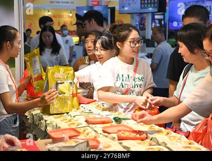 Nanning, région autonome chinoise du Guangxi Zhuang. 28 septembre 2024. Les visiteurs achètent des biscuits du Vietnam lors de la 21ème exposition Chine-ASEAN à Nanning, dans la région autonome du Guangxi Zhuang du sud de la Chine, le 28 septembre 2024. Les produits des pays de l'Association des Nations de l'Asie du Sud-est (ASEAN), tels que les durians, les biscuits et le bois de rose, ainsi que ceux d'autres pays, y compris les saucisses russes et les peluches d'alpaga péruvien, ont connu une grande popularité lors de la 21e exposition Chine-ASEAN à Nanning. Crédit : Zhou Hua/Xinhua/Alamy Live News Banque D'Images