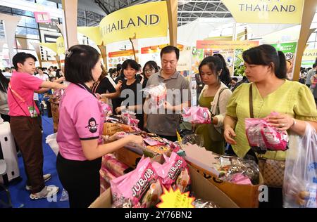 Nanning, région autonome chinoise du Guangxi Zhuang. 28 septembre 2024. Les visiteurs achètent des produits de Thaïlande lors de la 21ème exposition Chine-ASEAN au Centre international de congrès et d'exposition de Nanning à Nanning, dans la région autonome du Guangxi Zhuang du sud de la Chine, le 28 septembre 2024. Les produits des pays de l'Association des Nations de l'Asie du Sud-est (ASEAN), tels que les durians, les biscuits et le bois de rose, ainsi que ceux d'autres pays, y compris les saucisses russes et les peluches d'alpaga péruvien, ont connu une grande popularité lors de la 21e exposition Chine-ASEAN à Nanning. Crédit : lu Boan/Xinhua/Alamy Live News Banque D'Images