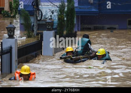 Katmandou, Népal. 28 septembre 2024. Des sauveteurs évacuent un résident piégé dans un quartier inondé de Lalitpur, Népal, 28 septembre 2024. Les inondations et les glissements de terrain déclenchés par les pluies incessantes au Népal ont fait au moins 59 morts et blessé 36 autres samedi après-midi, a indiqué la police. Crédit : Sulav Shrestha/Xinhua/Alamy Live News Banque D'Images