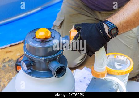 Les ouvriers d'entretien de piscine assemblent l'équipement de nettoyage de réservoir de système de filtre à sable Banque D'Images