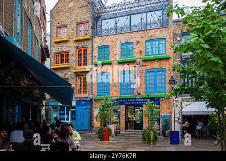 Londres, Royaume-Uni - 25 juillet 2024 : Colurful Neals Yard Courtyard. Neal's Yard est une petite ruelle de Covent Garden à Londres. Lieu touristique populaire. Banque D'Images