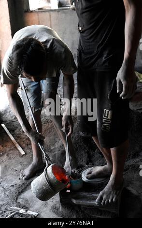 Ambatolampy, fonderie artisanale d'aluminium. Ouvrier avec creuset en fonte d'aluminium. Hauts plateaux centraux, région de Vakinankaratra, Madagascar. Banque D'Images