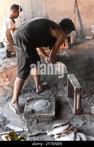 Ambatolampy, fonderie artisanale d'aluminium. Ouvrier démoulant. Hauts plateaux centraux, région de Vakinankaratra, Madagascar. Banque D'Images