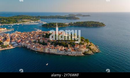 Nichées le long de l'Adriatique Azur, les maisons animées de Rovinj et le clocher emblématique s'élèvent au-dessus des eaux tranquilles, invitant les visiteurs à explorer la riche histoire et les paysages magnifiques au coucher du soleil. Banque D'Images