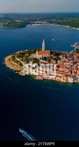 Nichée le long de la mer Adriatique, Rovinj captive avec sa charmante vieille ville, ses toits animés et ses eaux sereines. La lumière chaude du soleil danse sur les vagues, mettant en valeur son paysage pittoresque. Banque D'Images