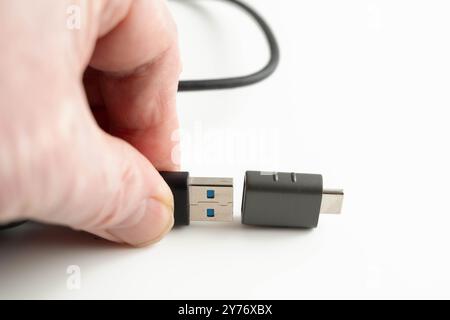 Personne connectant un câble USB mâle de type a à un connecteur USB femelle de type C dans l'informatique personnelle Banque D'Images