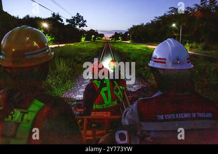 Les fonctionnaires et les travailleurs des chemins de fer d'État de Thaïlande sont assis sur un véhicule d'entretien tout en inspectant les voies pour assurer la sécurité et la préparation des rails et des traverses après les inondations dans la zone ferroviaire de Chiang mai. Avant la réouverture de la voie ferrée après une inondation, des inspections sont effectuées pour assurer la sécurité des passagers. L'état des voies est évalué pour s'assurer que les niveaux d'eau ne dépassent pas les normes établies et que les voies ne doivent pas être endommagées. En outre, le système de signalisation, l'équipement de contrôle et les panneaux de limitation de vitesse sont vérifiés avant que les experts donnent leur accord pour reprendre le train O. Banque D'Images