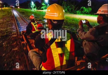 Des fonctionnaires et des travailleurs de la Compagnie des chemins de fer d'État de Thaïlande sont assis sur un véhicule d'entretien tout en inspectant les voies ferrées pour assurer la sécurité et la préparation des rails et des traverses après les inondations dans la zone ferroviaire de Chiang mai. Avant la réouverture de la voie ferrée après une inondation, des inspections sont effectuées pour assurer la sécurité des passagers. L'état des voies est évalué pour s'assurer que les niveaux d'eau ne dépassent pas les normes établies et que les voies ne doivent pas être endommagées. En outre, le système de signalisation, l'équipement de contrôle et les panneaux de limitation de vitesse sont vérifiés avant que les experts donnent leur accord pour reprendre l'exploitation des trains Banque D'Images