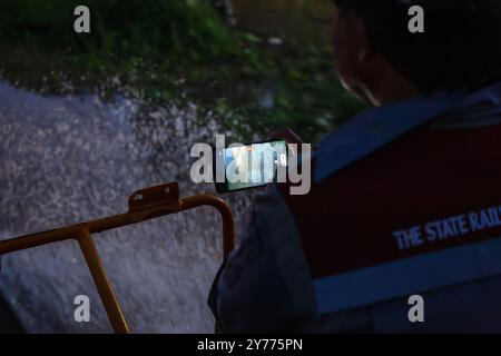 Un agent de maintenance des chemins de fer d'État de Thaïlande filme assis sur un véhicule de maintenance pendant l'inspection pour assurer la sécurité et la préparation des rails et des traverses après les inondations dans la zone ferroviaire de Chiang mai. Avant la réouverture de la voie ferrée après une inondation, des inspections sont effectuées pour assurer la sécurité des passagers. L'état des voies est évalué pour s'assurer que les niveaux d'eau ne dépassent pas les normes établies et que les voies ne doivent pas être endommagées. En outre, le système de signalisation, l'équipement de contrôle et les panneaux de limitation de vitesse sont vérifiés avant que les experts donnent leur accord pour reprendre Banque D'Images