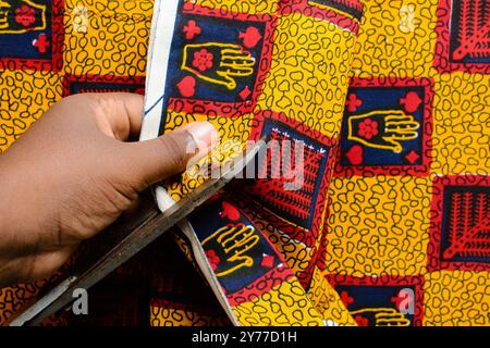 vue de dessus de couper le tissu ankara avec des ciseaux, flatlay de tissu de cire nigérian Banque D'Images