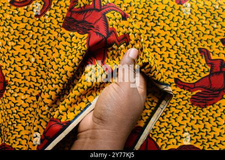 vue de dessus de couper le tissu ankara avec des ciseaux, flatlay de tissu de cire nigérian Banque D'Images