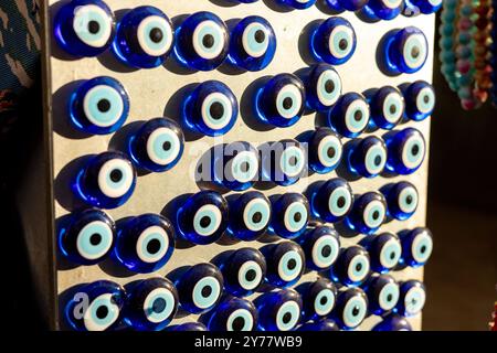 Collection unique de breloques bleues pour yeux maléfiques exposées dans un cadre de marché pendant la journée Banque D'Images