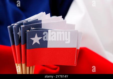 Groupe de drapeaux en papier chilien sur fond de tissu rouge, blanc et bleu Banque D'Images