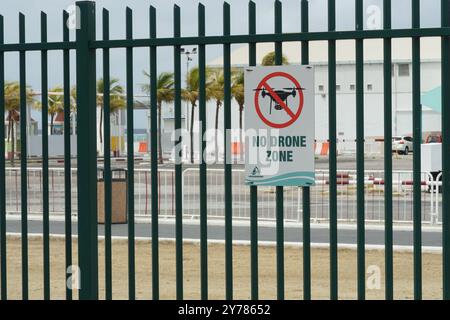 Affiche avec silhouette de drone dans un cercle rouge croisé et texte no drone zone situé sur une clôture verte à Oranjestad, Aruba. Banque D'Images