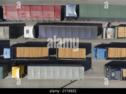 Transport de marchandises. De nombreux camions attendent en file d'attente pour le déchargement dans le port portuaire, vue de dessus d'un quadricoptère sur les camions chargés de grain. Concep Banque D'Images