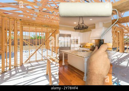 Avant et après de l'homme Painting Roller sur le cadre de construction pour révéler terminé et nouvelle cuisine. Banque D'Images