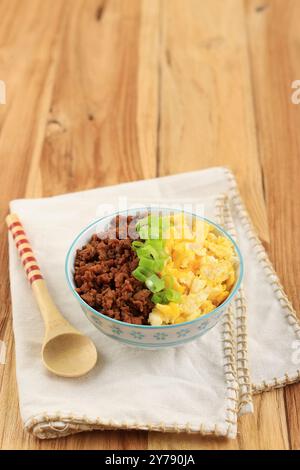 Boeuf Soboro Don. Boîte à lunch de riz japonais tricolore avec bœuf haché sauté, œufs brouillés et oignon de printemps Banque D'Images