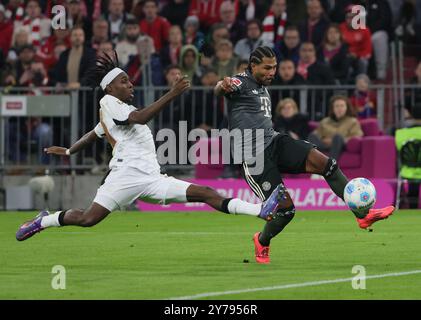 Munich, Allemagne. 28 septembre 2024. Jérémie Frimpong (G) de Leverkusen affronte Serge Gnabry du Bayern Munich lors du match de première division de Bundesliga entre le Bayern Munich et le Bayer 04 Leverkusen à Munich, Allemagne, le 28 septembre 2024. Crédit : Philippe Ruiz/Xinhua/Alamy Live News Banque D'Images