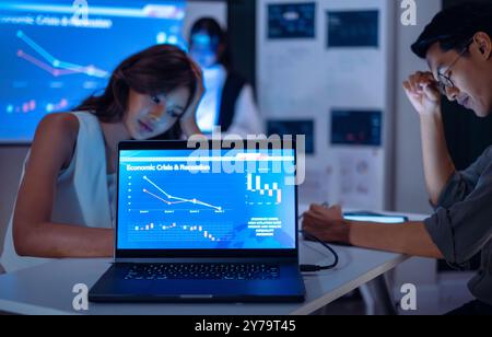 équipe des finances obtenir le stress lors de l'analyse des données de la crise économique et des impacts de la récession lors d'une réunion tard dans la nuit dans un bureau Banque D'Images