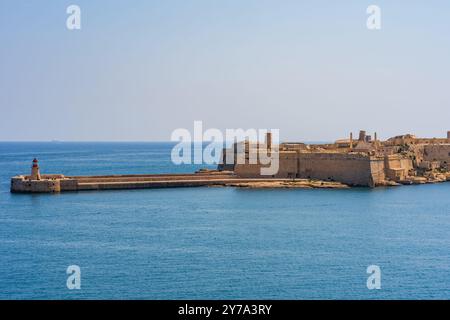 Phare sur le brise-lames Ricasoli East et Fort Ricasoli à Valletta Grand Harbour, Malte. Banque D'Images