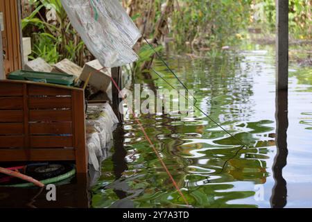 Les eaux de crue sur le jardin et dans la maison atteignent presque le lit en bois, le sol submergé sous l'eau - dommages causés par les forces de la nature Banque D'Images