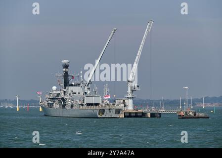 La frégate HMS Portland dans le port de Portsmouth embarque à bord de l'armement. Fait au milieu de l'eau en cas d'accident. Septembre 2024 Banque D'Images