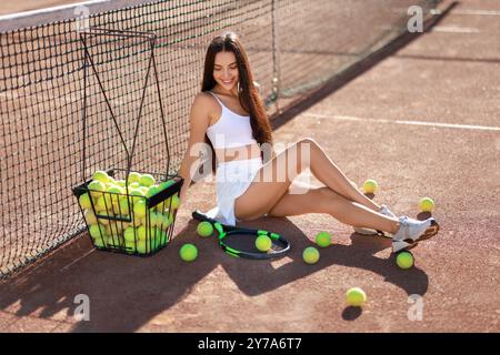 Belle femme en vêtements de sport sur court de tennis Banque D'Images